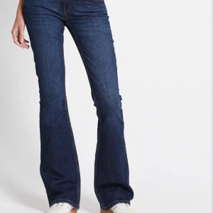 Mörkblå bootcut jeans - Snygga mörkblå jeans med bootcut passform och klassiska fickor bak. Jeansen har en låg midja och är tillverkade i ett stretchigt denimtyg som sitter bekvämt. 