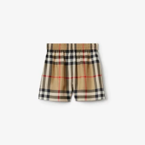 Beige rutiga shorts från Burberry - Klassiska beige shorts med Burberrys ikoniska rutor i svart, vitt och rött. De har elastisk midja och en avslappnad passform, perfekta för varma dagar. Stilen är tidlös och passar dig som gillar en trendig look.