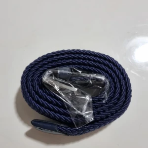 Mörkblå grisch belte - Säljer ett mörkblå flätat bälte med snygg läderdetalj vid änden. Bältet har en stilren design och passar perfekt till jeans eller byxor. Enkel att justera för bästa passform.