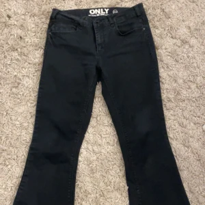 Svarta bootcut jeans från ONLY - Säljer ett par svarta bootcut jeans från ONLY. Jeansen har klassisk femficksdesign, normal passform upptill och utsvängda ben. Inte använda ofta 