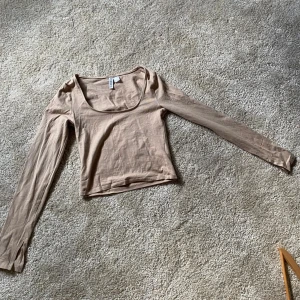 Beige croppad långärmad topp från H&M Divided - Säljer en beige croppad långärmad topp från H&M Divided. Toppen har en rundad, något djupare halsringning och är tillverkad i mjuk bomull. Perfekt att styla med jeans eller kjol💞