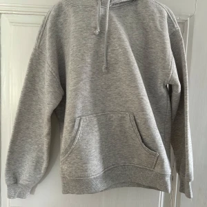 Grå hoodie från BikBok - Säljer en klassisk grå hoodie från BikBok i storlek XS. Tröjan har huva, magficka och ribbade muddar vid ärmslut och nederkant. Passar som st S också.