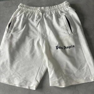 Palm Angels Shorts - Säljer ett par vita riktigt fräscha shorts från Palm Angels nu inför sommaren 🏝️ Storleken är M men dessa shorts kan även passa för dom som har strl L. Shortsen är endast använda en gång så skicket är som nytt! Priset är billigt redan så kom inte med skambud! Tack på förhand 🤝!