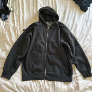 Svart hoodie från Brandy Melville - En svart hoodie med dragkedja och huva. Tröjan har två stora fickor framtill och ribbade muddar vid ärmslut och nederkant. Perfekt för en avslappnad stil. Onesize men sitter oversized, modellen heter Christy zip up hoodie