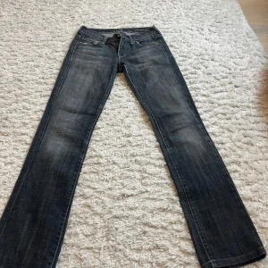 Mörkgrå jeans från 7 For All Mankind - Snygga mörkgrå jeans från 7 For All Mankind med klassisk femficksdesign och raka ben. Midjemått rakt över: 35cm innerbenslängd: 78cm 