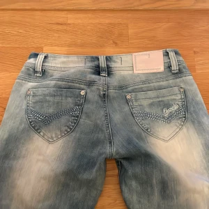 Ljusblå lowwaist bootcut jeans med detaljer - Midjemått 38cm tvärs över, grenhöjd 17cm och innerbenslängd 76cm🩷Skriv om du har frågor eller för bild på