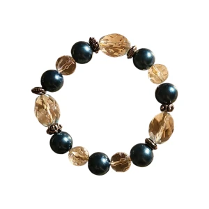 Elastiskt armband med pärlor och glaspärlor - Snyggt armband med stora svarta pärlor och facetterade, transparenta glaspärlor i beige. Armbandet är elastiskt och har små metalliska detaljer mellan pärlorna. Perfekt accessoar för att lyfta din outfit.