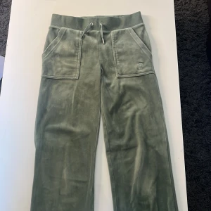 Gröna Juicy Couture byxor - Juicy byxor i grön färg. Ser ut som på bilden. Säger pga att jag inte använt dem på något år. Använt ett par gånger. Ena silver delen där fram har lossnat, men inget man lägger märke till. Inget annat fel på dem. Dem är som helt vanliga annars. 