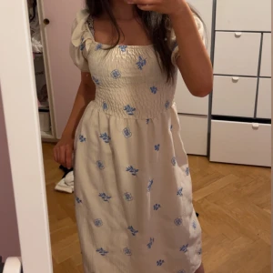 Vit klänning med blått blommönster - Köpte denna klänningen utomlands använt bara 1 gång. Pris kan diskuteras💕