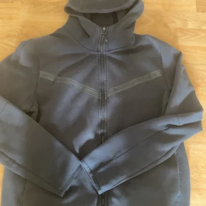 Nike tech old season - Säljer en svart old season Nike tech i storlek L. Ganska bra skick men tyvärr så är sträcken skrynkliga då en gång tvättmaskinen gick sönder och den var fast i vatten i flera dagar. Pris ej hugget i sten hör av er vid frågor.