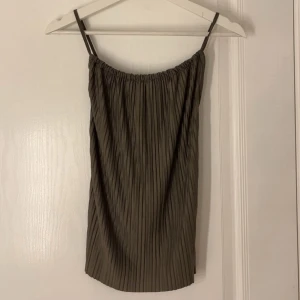 Topp från Gina Tricot - Supersnygg mörkgrön topp från Gina Tricot med tunna axelband som korsas i ryggen. Storlek XS. Aldrig använd💗