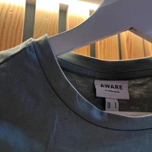 Mörkgrön  t-shirt med puffärm från Vero Moda - Snygg mörkgrön t-shirt från AWARE by Vero Moda med puffiga kortärmar och rund halsringning. Tillverkad i mjuk bomull som känns skön mot huden. Perfekt för dig som vill ha en basic tee med en twist.