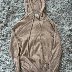 Beige hoodie i merinoull/kashmir XS - Supermjuk beige hoodie från S & T Clothing i lyxig mix av merinoull och kashmir. Tröjan har huva med snörning och långa ärmar, perfekt för en chill och stilren look. Passar dig som gillar neutrala färger och vill ha något riktigt bekvämt.