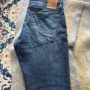 Mörkblå jeans från Jack & Jones  - Säljer ett par mörkblå jeans från Jack and Jones, väldigt fint skick då dom i princip bara legat i garderoben sen i januari. Storlek 30/32. Hör av dig vid funderingar!