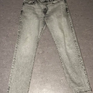 Grå tvättade raka jeans - Snygga grå jeans med tvättad look och raka ben. Klassisk femficksmodell med normal passform och midja. Perfekta till sneakers och hoodie för en chill stil.