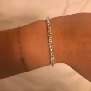 Glittrigt silverfärgat armband - Säljer ett stilrent armband i silverfärg med gnistrande stenar runt hela bandet. Armbandet är smalt och flexibelt, perfekt för att stapla flera tillsammans för en extra glittrig look                     1st för 40kr                                                                    2st för 60kr                                                                    3st för 100kr