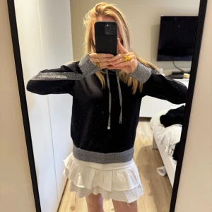 Svart hoodie med grå glitterdetaljer - Svart hoodie med glitterdetaljer från Karl Lagerfeld! Aldrig använd så därför är den i nyskick och har inga defekter! Säljer då den inte riktigt kommer till användning💗