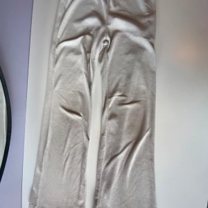 Beige mjukisbyxor  - Supermjuka beige mjukisbyxor från H&M i storlek 140. Byxorna har en enkel och clean design med resår i midjan och är gjorda i ett gosigt fleecematerial. Perfekta för chill dagar eller när du vill vara extra bekväm.
