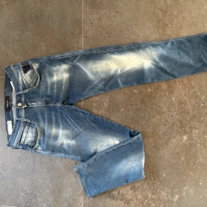 Blå Replay Hyperflex jeans - Säljer ett par blå Replay Hyperflex jeans med snyggt slitna detaljer och klassisk femficksdesign. Använda med försiktighet hör av er vid frågor, pris kan diskuteras vid snabb affär 🤝