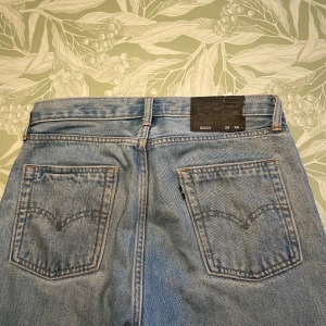 Levi's Baggy jeans ljusblå 29/30 - Ljusblå baggy jeans från Levi's i klassisk denim med raka ben och två bakfickorna. Otroligt tjocka och slitstarka jeans, de bästa jeansen jag haft. Jeansen har en avslappnad passform och är tillverkade i bomull. Perfekta för en chill och trendig look.