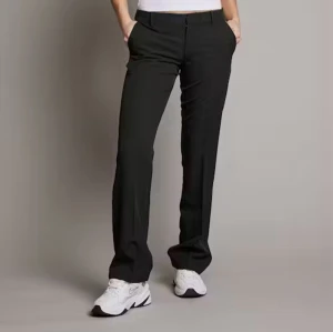 Svarta kostymbyxor  - Snygga svarta kostymbyxor med bootcut-snitt och klassisk passform. Byxorna har hällor för bälte, diskret dragkedja och raka ben som får en lätt utsvängd look nertill. Perfekta för en clean och stilren vibe. 