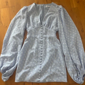 Ljusblå blommig klänning från Adoore - Supersöt ljusblå kortklänning från Adoore med små vita blommor, storlek 34