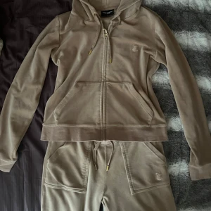 Juicy Couture set beige - Ett äkta Juicy Couture set i beige, byxorna är storlek XS och tröjan storlek M! Säljer pga att det är för litet på mig. Både tröjan och byxorna är mycket bra skick, har använt dom men nästan som nya!😍Tvättar kläderna innan jag skickar!😊🫶