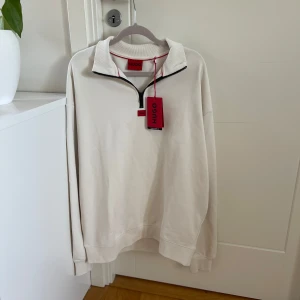 Vit half zip tröja från Hugo Boss  - Helt ny och oanvänd tröja från Hugo Boss med prislapp kvar. Nypris 1200kr. 