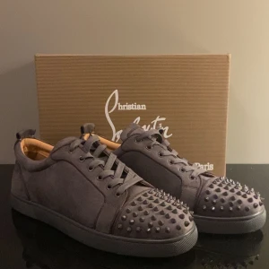 Louboutin (Loubs) - Säljer ett par mörkgråa Loubs. Använt ett par gånger, men ser helt nya ut. Alla spikar sitter och inga skador på skorna heller. Har låda och kvitto. Vid snabbaffär kan ja sänka priset. Vill du ha flera bilder eller undrar något, kom privat.