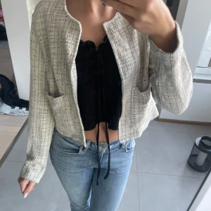 Beige rutig overshirt från Kappahl XS - Säljer en beige och svart rutig overshirt från Kappahl i storlek XS. Jackan har en boxig passform, två stora fickor framtill och är tillverkad i ett strukturerat tyg som ger en trendig look. Perfekt att slänga över en topp och jeans för en chill vibe.