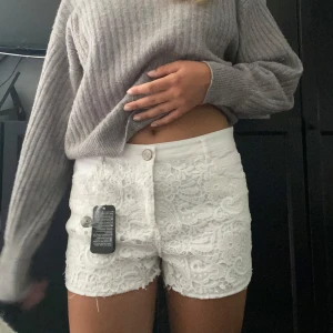 Vita spetsdetaljerade shorts - Snygga vita shorts med blommig spets framtill. Helt nya med alla lappar kvar. Storlek 40 men passar mig som normalt har storlek S!