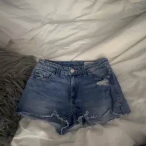 Blå jeansshorts  - Blåa jeans shorts från plick, använd ett få par gånger. Ser högmodjade ut, men på sitter de väldigt lågmidjat. Köpta för 320kr.
