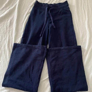 Mörkblå mjukisbyxor från Gina Tricot - Mörkblå mjukisbyxor från Gina Tricot i storlek XXS. Byxorna har breda ben, resår i midjan och snörning framtill. Tillverkade i mjukt bomullsmaterial för en chill och bekväm vibe.💖