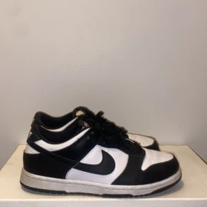 Svarta och vita Nike Dunk - Snygga Nike Dunk i svart och vitt med klassisk design. Skorna har snörning och en bekväm passform. Perfekta för en stilren look.