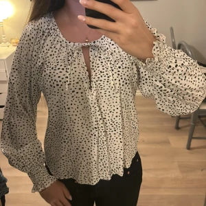 Sprickig blus  - Säljer denna jättefina svart prickiga blusen från Lindex då den inte längre kommer till användning 🙃 Man kan knyta den där uppe eller välja att inte ha den knuten, Storlek XS men passar även S