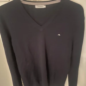 Mörkblå stickad tröja från J.Lindeberg - Stickad tröja från j lindeberg i storlek L. Inga defekter på tröjan hör av dig vid eventuella frågor.