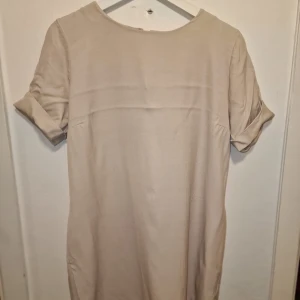 Beige/rosa klänning från Rodebjer - Säljer en stilren beige klänning från Rodebjer i storlek S. Perfekt för en minimalistisk look. Snyggt med overknee stövletter till.
