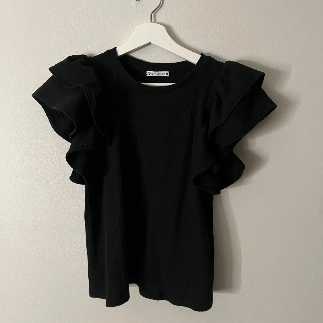 Svart topp med volangdetaljer