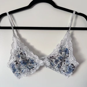 Blommig bralette - Säljer en söt bralette med blommigt mönster i blått och vitt. Den har fina spetsdetaljer runt kanterna och justerbara axelband för bästa passform. Perfekt för att känna sig extra fin! Liten i storleken! Använd en handfull gånger 💙 Önskar du veta exakta mått? Tveka inte att höra av dig!