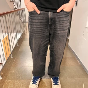 Svart jeansbyxor H&M - Snygga svarta jeans med en klassisk tvätt och femficksdesign.De är tillverkade i slitstarkt denim. Använda sparsamt men slitna i änden av vänstra benet som man kan se på bilderna.