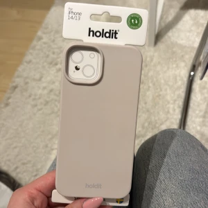 Beige mobilskal från Holdit för iPhone 14/13 - Snyggt och stilrent beige mobilskal från Holdit, designat för iPhone 14/13. Det är i silikon och använt i 2 dagar tills jag insåg de va lite för litet för min 15. Köpt för 200