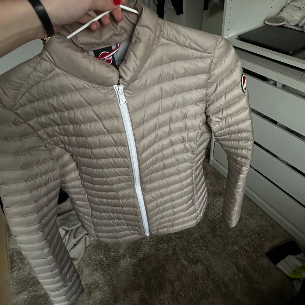 Säljer en snygg beige pufferjacka från Colmar. Jackan har en dragkedja framtill och är quiltad för extra värme. Perfekt för kyligare dagar. Den har en stilren design med Colmar-logga på ärmen.. Takit.