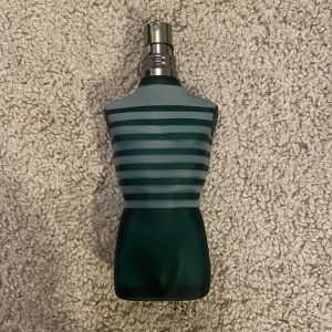 Le Male Eau de Toilette från Jean Paul Gaultier - Säljer en ikonisk Le Male Eau de Toilette från Jean Paul Gaultier. Flaskan är formad som en manlig torso i frostat glas med gröna och blå ränder. Parfymen kommer i en unik metallförpackning. Volymen är 75 ml.