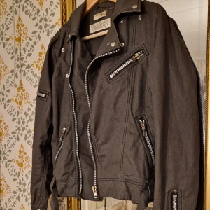 Kuyichi bikerjacka - Snyggaste bikerjackan i lite vaxad bomull från japanska märket OT Kuyichi  Storlek M.  Skick: Man kan se veck i tyget där armar etc böjts, förstärker bara jackans look tycker jag. Hittar inga andra anmärkningar när jag granskar jackan.  (dyr i inköp)