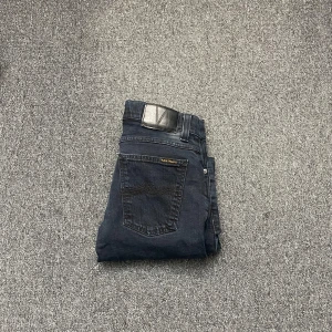 Svarta jeans från Nudie - Snygga svarta jeans från Nudie med klassisk femficksdesign. De har en normal passform och är tillverkade i slitstarkt denim. Perfekta för en stilren look.