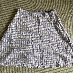 Lila blommig kjol -  Väldigt mjuk kvalite, Väldigt fin lila färg med blommor. Tyvärr råkade jag klippa bort lappen på denna också. Förlåt! Har knappt använt!! Men jag gissa på att det är S