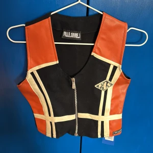 Svart och orange väst från Fille Suivre - Snygg svart och orange väst från Fille Suivre med coola vita detaljer och en dragkedja framtill. Snygg passform och mycket cool stil, lite biker vibb kanske!😆