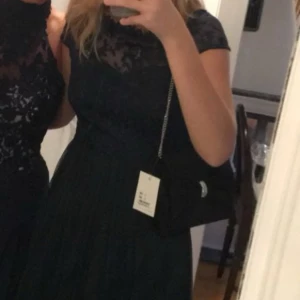 Vila Mörkblå balklänning - Elegant mörkblå klänning med spetsdetaljer och kortärmad design. Storlek S 