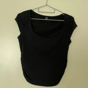 Svart kortärmad topp från Shein - Snygg svart topp från Shein i en enkel och stilren design. Toppen har korta ärmar och en rundad halsringning, perfekt för en minimalistisk look. Passar bra till både jeans och kjol.