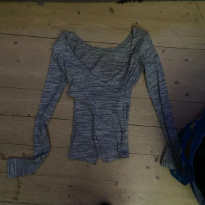 Grå ribbad tröja från BikBok - Säljer en stilren grå ribbad tröja från BikBok. Tröjan har en v-ringad design och långa ärmar, perfekt för en avslappnad look. Passar bra till både jeans och kjol. Perfekt för höst och vår!